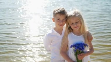 Güneşli bir günde gölette kardeş, mutlu çocuklar, çocuklar için yaz tatili, çocuklar nehir kenarında eğleniyor.