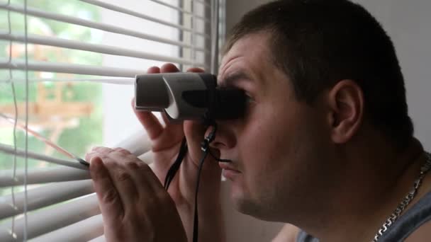 A strange man looks through binoculars — Stock Video