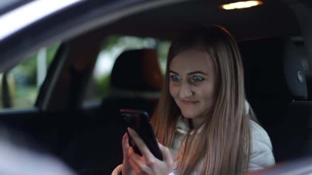 Жінка, використовуючи смартфон у своїй машині, здивована жінка відкриває очі широко — стокове відео