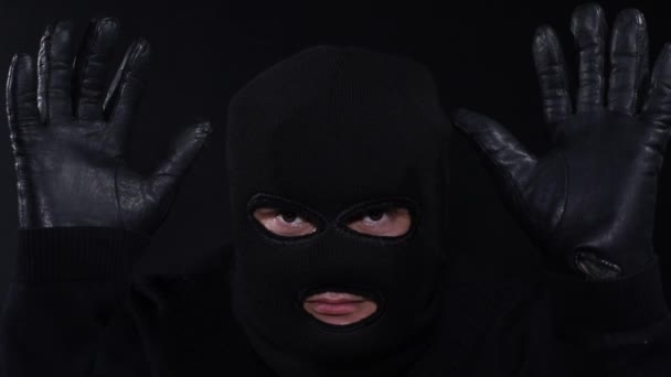 Kvarhållen brottsling i en mask, ett team av poliser (händerna bakom huvudet), — Stockvideo