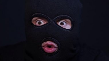 Kar maskeli bir terörist rehineyi korkutur.