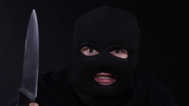 Maske takan ve elinde bıçak tutan korkunç bir suçlu..