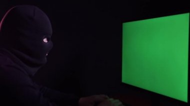 Hacker bilgisayar monitörüne, kromakey ekrana bakıyor
