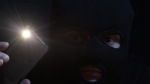 Terrorist in a balaclava with a flashlight in his hands — Stock Video