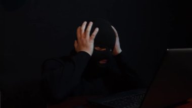 Maskeli bir suçlu kişisel bilgileri çalmak için interneti kullanıyor.,