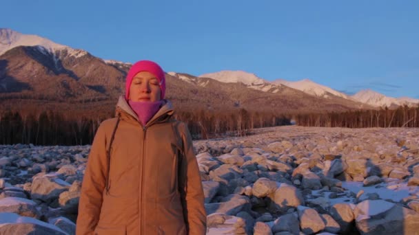 Mujer joven medita al pie de las montañas . — Vídeo de stock