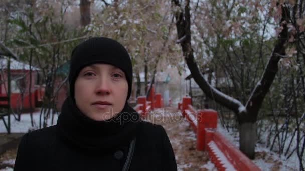 Retrato de una chica vestida de negro en el parque en invierno — Vídeos de Stock