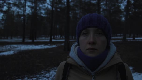 Retrato de una niña en un frío bosque de invierno oscuro — Vídeos de Stock