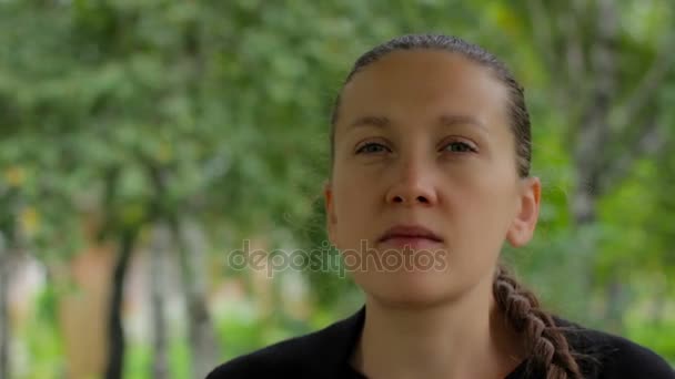 Retrato de una niña sobre un fondo de follaje verde de abedules en el verano — Vídeos de Stock