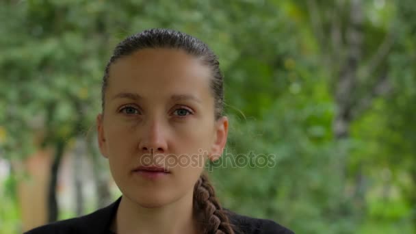 Retrato de una niña sobre un fondo de follaje verde de abedules en el verano — Vídeos de Stock