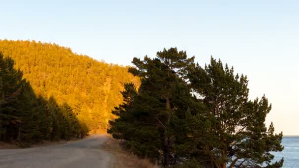 Strada sterrata lungo la costa in autunno, al tramonto — Video Stock