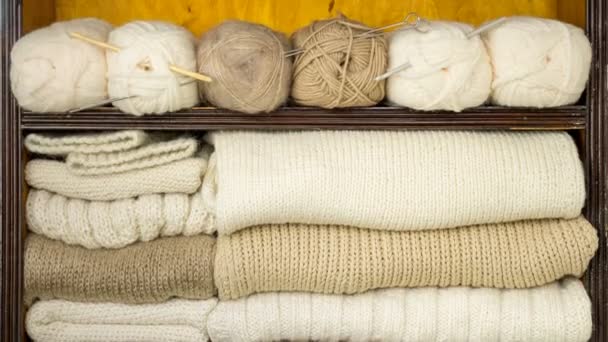 Main prend les boules de laine, aiguilles à tricoter, tissus de laine des étagères — Video