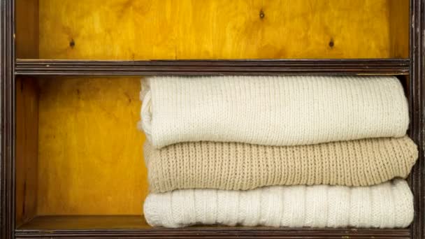 Mão enche prateleiras por bolas de lã, agulhas de tricô, tecidos de lã acabados — Vídeo de Stock