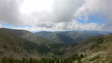 Etrafı dağlarla çevrili, vadinin üzerinde uçan bir paraglider. Pov