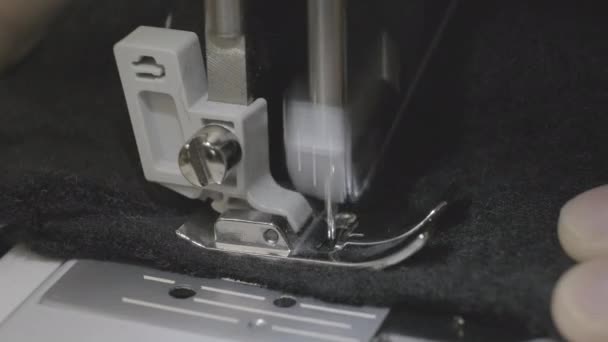 4K footage. Close up of a woman sewing black fabric with a sewing machine — Stockvideo