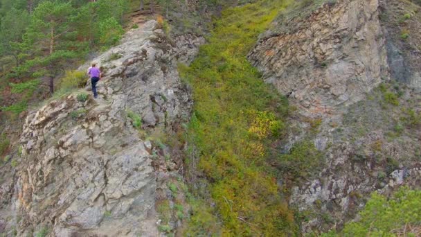 Rastreo aéreo de una chica trepando sobre una roca. Movimiento lento — Vídeos de Stock