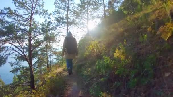 在阳光灿烂的日子，头戴头巾背着背包的女孩沿着陡峭的斜坡走着 — 图库视频影像