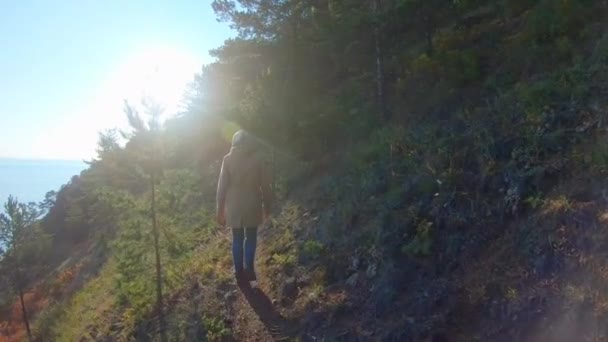 Femme marche sur une pente raide du bord de la mer. Vue arrière, ralenti — Video