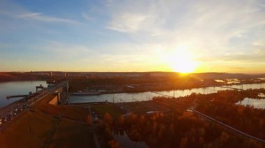 Aerial view of industrial urban landscape: river, dam, buildings at sunset