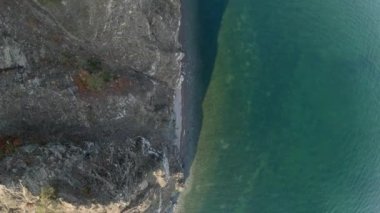 Drone flying above the coastline of sea. Aerial view, top down