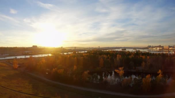Stad en rivier bij zonsondergang. Stedelijk industrieel landschap vanuit vogelperspectief — Stockvideo
