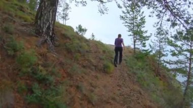 Kız güzel bir manzarayla dağa koşar ve ellerini havaya kaldırır.