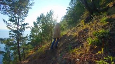 Kız güneşli bir günde tepeye tırmanır. Arka plan, yavaş çekim