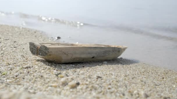 Abandonado solitario viejo juguete barco de madera se encuentra en la playa. De cerca. — Vídeo de stock