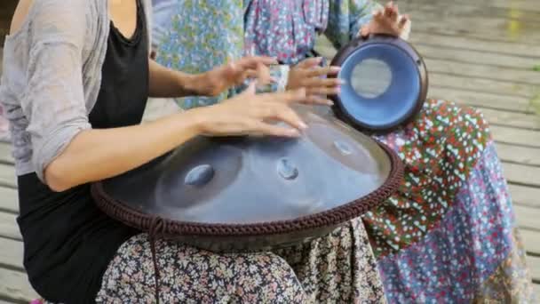 Close-up de meninas mãos tocando tambor do tanque ou pendurar em concerto étnico ao ar livre — Vídeo de Stock