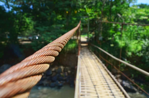 Eski bir bambu asma köprü, paslı demir kablo