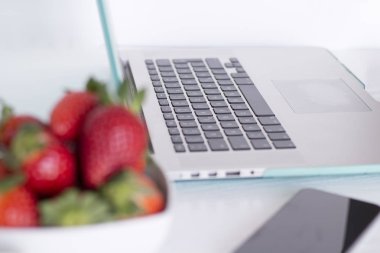 Dizüstü bilgisayar ve beyaz arka plan üzerinde çilek