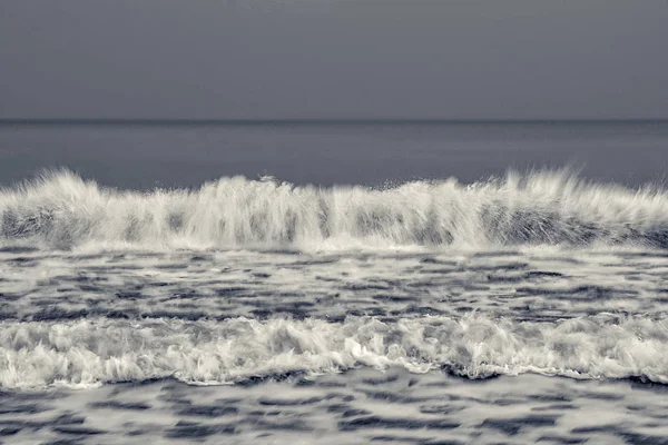 Onda fria. Foco seletivo. Longa exposição. superfície preta do mar branco para fundo. Acções . — Fotografia de Stock