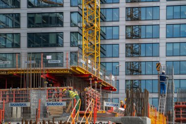 Binanın tepesindeki iskelenin yanında yürüyen bir işçi. 18 Şubat 2019. Varşova, Polonya.