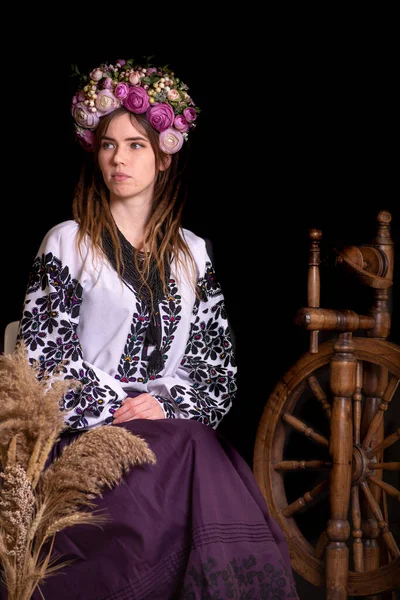 Modern Ukrainian national clothes. Portrait of a beautiful woman with dreadlocks in an embroidered national dress on a black background. Ukrainian style.