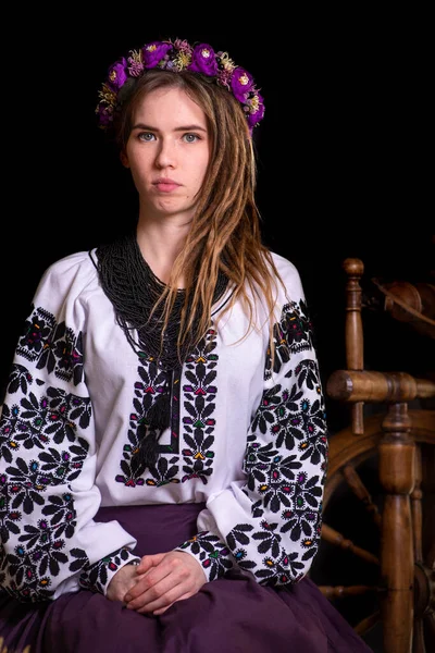 Modern Ukrainian national clothes. Portrait of a beautiful woman with dreadlocks in an embroidered national dress on a black background. Ukrainian style.