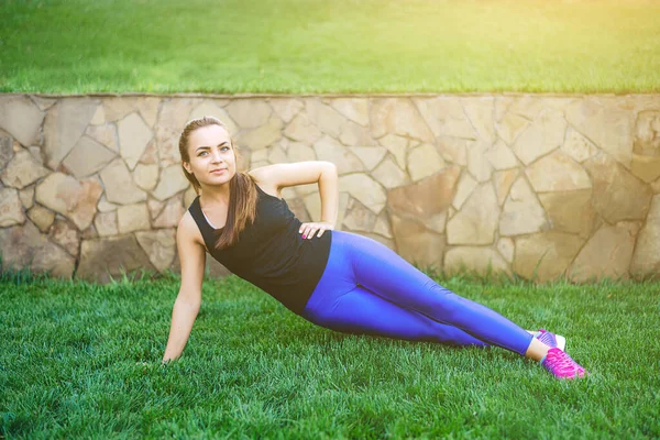 Doğada genç bir kadın spor ve yogayla meşgul. Sağlıklı bir yaşam tarzı. Rahatlama kavramı modern kadın. Doğanın resmi. Spor, spor, açık havada yoga, parkta..