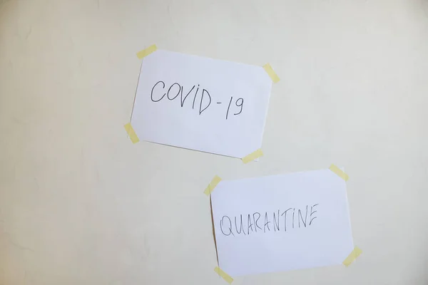 Dos etiquetas covid-19 y cuarentena en una hoja pegada a la pared. El concepto de autoaislamiento. Coronavirus, detenga la propagación de la infección. 2019-ncov . —  Fotos de Stock