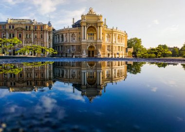 Sabah ışığında Odessa Operası 'nın yansıması. Koronavirüs salgınının karantinası sırasında boş bir şehir. İnsansız bir şehir. Odessa, Ukrayna. 10 Mayıs 2020