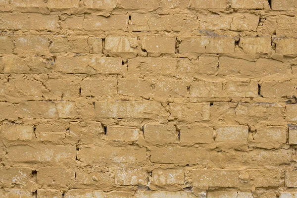 Arka plan eski yıpranmış sarı tuğla duvar.