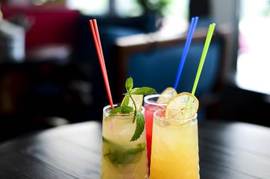 Arkaplanı bulanık limonlu üç farklı içki. Boşluğu en düşük şekilde kopyala