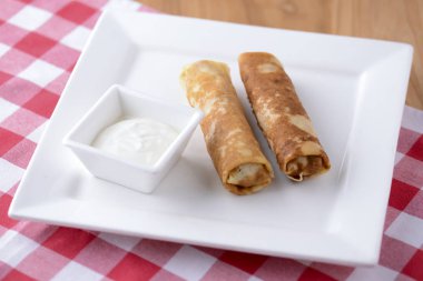 Frech krepleri, iki lezzetli krep un ve ekşi kremayla servis edilen ekşi kremayla yapılmış ekşi arkaplanda..