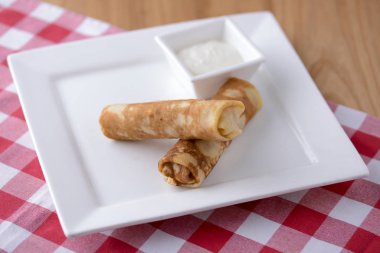 Frech krepleri, iki lezzetli krep un ve ekşi kremayla servis edilen ekşi kremayla yapılmış ekşi arkaplanda..