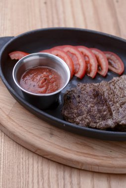 Kahvaltı öğle yemeğini mantar, domates ve sosisle karıştırıp siyah tabakta servis et.