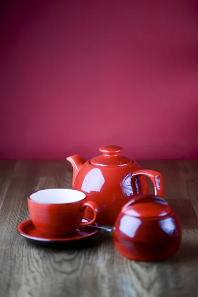 Red and white tea set with on dark wooden table with hot pink background. — 스톡 사진