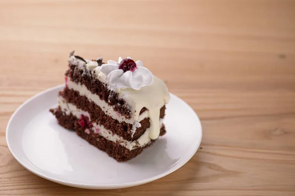 Ciasto czekoladowe waniliowe z galaretką wiśniową, zwieńczone polewą z białego sera i kawałkami czekolady — Zdjęcie stockowe