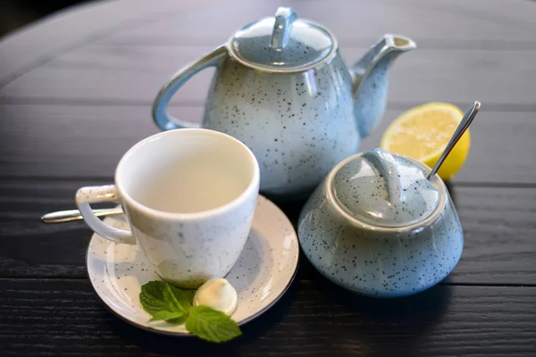 Blauwe en witte theeset met munt en een schijfje citroen op donker houten tafel. — Stockfoto
