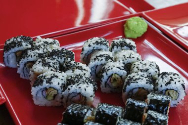 Geleneksel suşi ruloları, zencefil ve wasabi soslu, yakın çekim, seçici odaklanma. Japon mutfağı..
