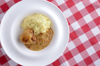 Geleneksel mutfak, soslu patates püresi, et ve dereotu ekose arka planda beyaz bir tabakta servis edilir.