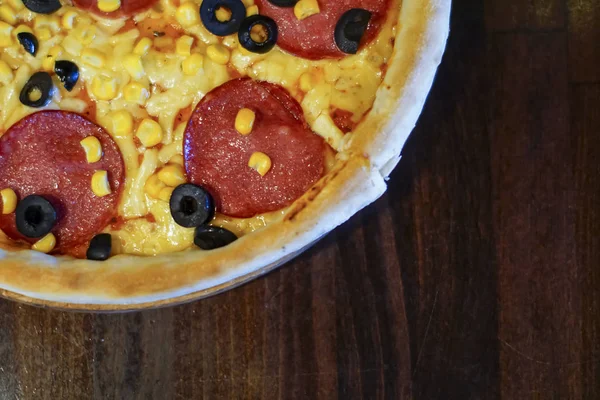 Pizza fresca deliciosa com carne, tomates e cogumelos servidos em uma placa em mesa de madeira escura, close-up — Fotografia de Stock