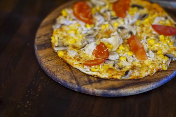 Pizza fresca deliciosa com carne, tomates e cogumelos servidos em uma placa em mesa de madeira escura, close-up — Fotografia de Stock